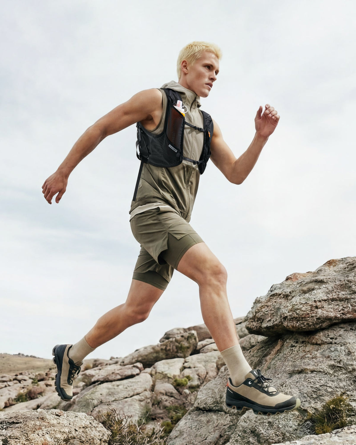 AMP10225 - Dynamic Shield™ Running Vest | A721 L-XL in Black worn by a runner climbing rocky terrain outdoors.