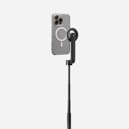 AMP07659 - Tripod Selfie Stick (Mag Fit) | S580W in Black showing an iPhone in a clear MagSafe case mounted to the S580W selfie stick in extended tripod mode, displayed against a light gray background.