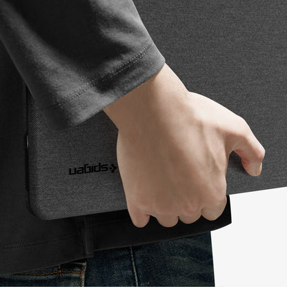 ACS11541 - MacBook Neo 13-inch Urban Fit in Black showing close up of case tucked under arm, logo detail visible