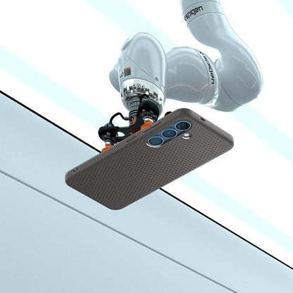 ACS08980 - Galaxy S25 Plus Case Liquid Air in Marble Gray showing the robotic arm holding the device in an elevated horizontal position, angled slightly upward. Showing the device back facing outward, revealing its camera module. The robotic arm is positioned above a clean, structured background with defined panels